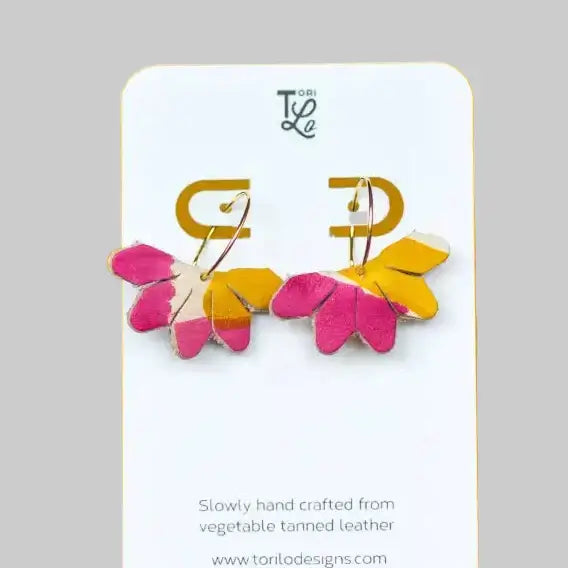 Pair of colorful earrings on a branded card with a gray background