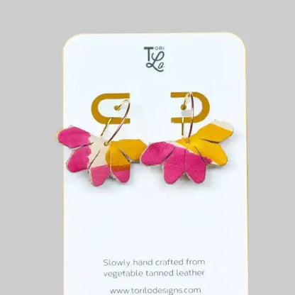 Pair of colorful earrings on a branded card with a gray background