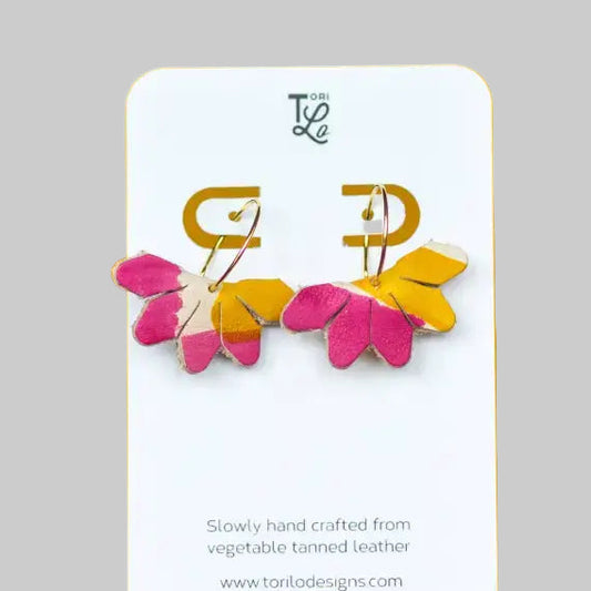 Pair of colorful earrings on a branded card with a gray background