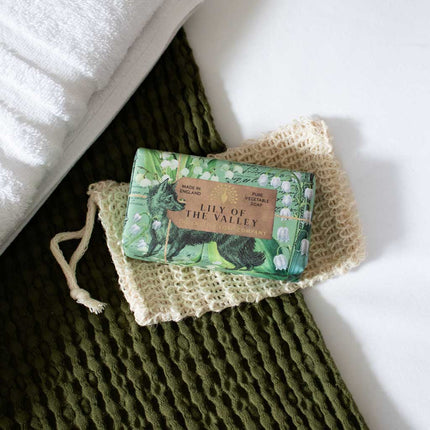 Bar of soap with 'Lily of the Valley' packaging on a textured green surface