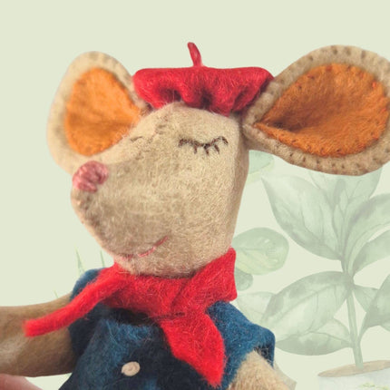 Stuffed mouse toy with a red bow tie and blue vest on a light background