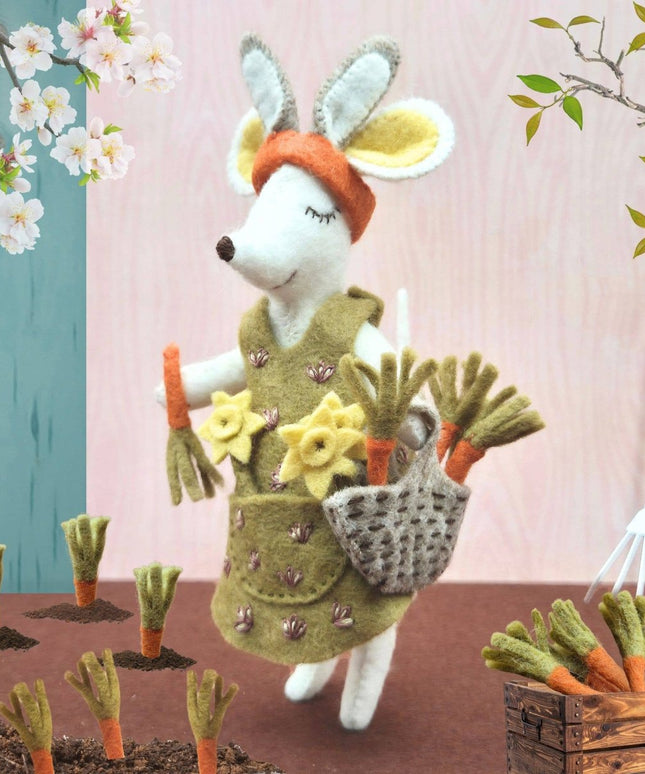 Toy rabbit in a garden setting with flowers and tools