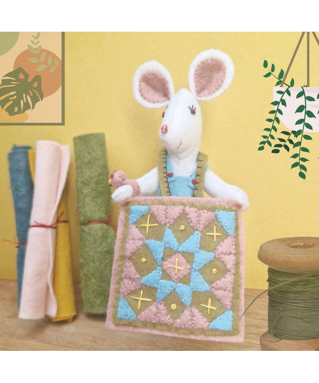 Stuffed mouse toy with a quilt on a yellow background
