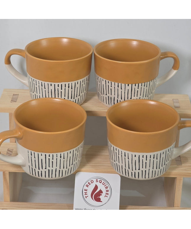 Four ceramic mugs with tan interiors and white exteriors featuring black horizontal stripes.