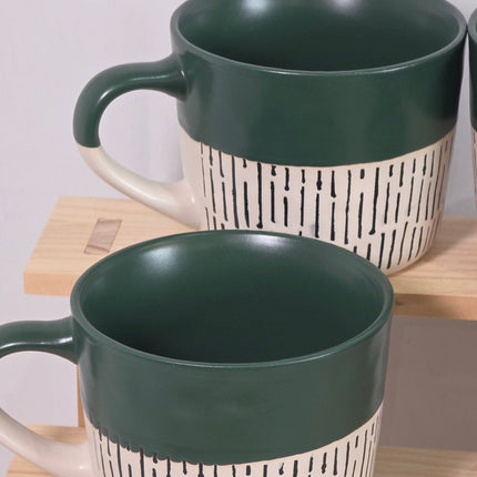Two ceramic mugs with dark green interiors and exteriors