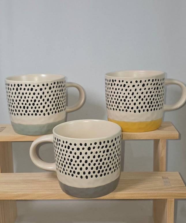 Three ceramic mugs with a black polka dot pattern on a cream body, 