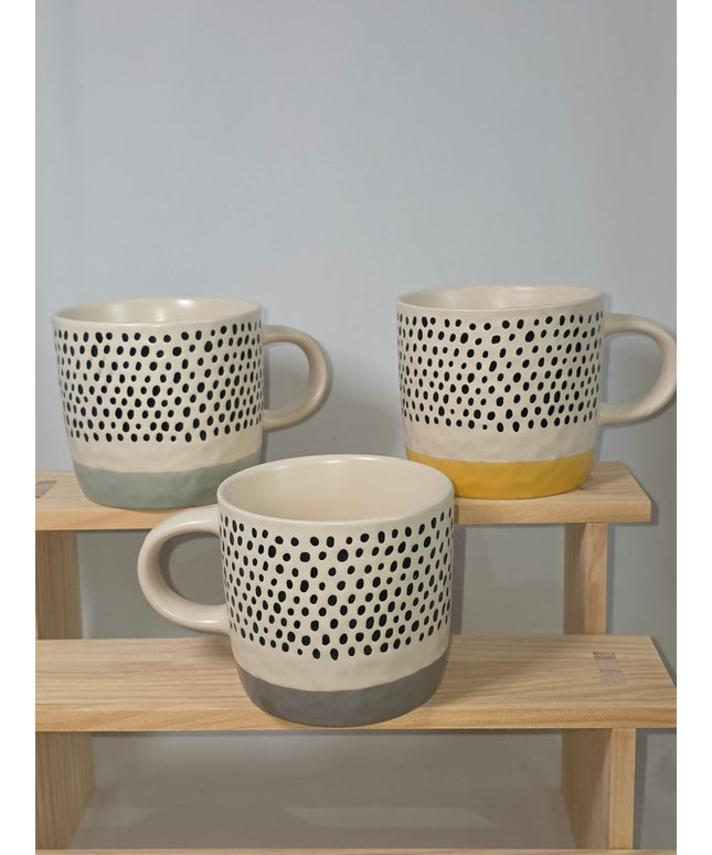 Three ceramic mugs with a black polka dot pattern on a cream body, 
