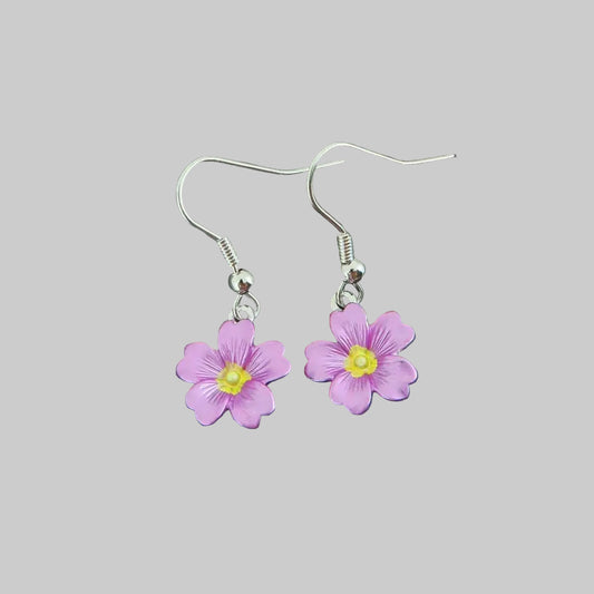 Flower-shaped earrings on a stone surface