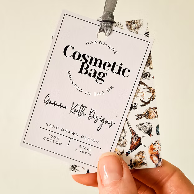 Handmade cosmetic bag label held by a hand with a patterned background