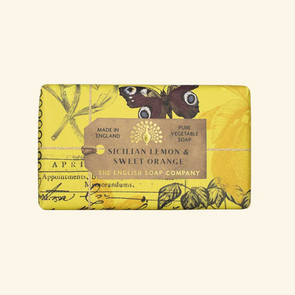 Yellow soap bar with botanical design and label on a beige background