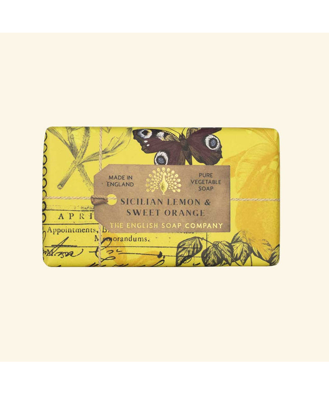 Yellow soap bar with botanical design and label on a beige background