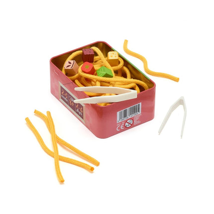 A red metal tin filled with yellow pipe cleaners and small wooden blocks, with two white plastic tweezers placed beside it on a white background.