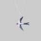 Silver swallow pendant necklace on a gray background