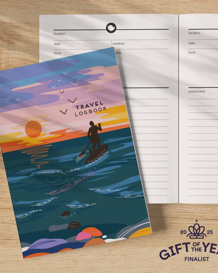 Travel logbook with a sunset design on a wooden surface